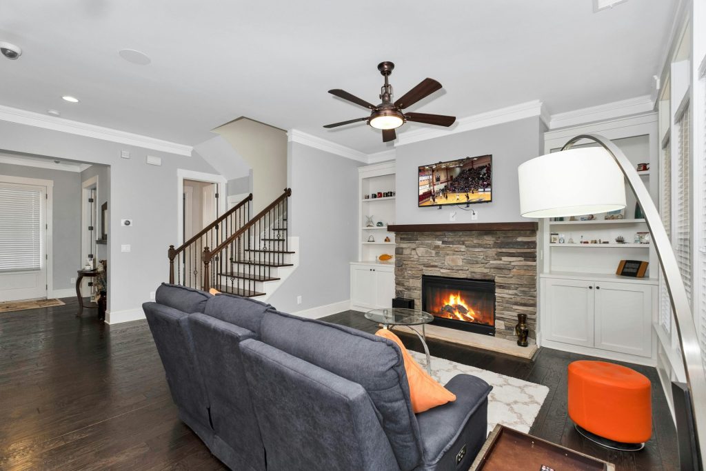 Schwarzer Flachbildfernseher neben grauem Sofa eingeschaltet